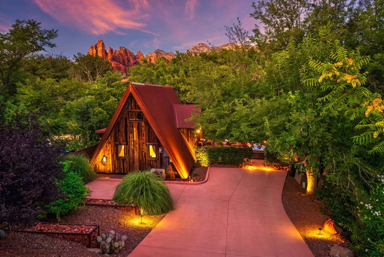 Aerial view of Creekside 88 A-frame with red rocks and green trees — summer
