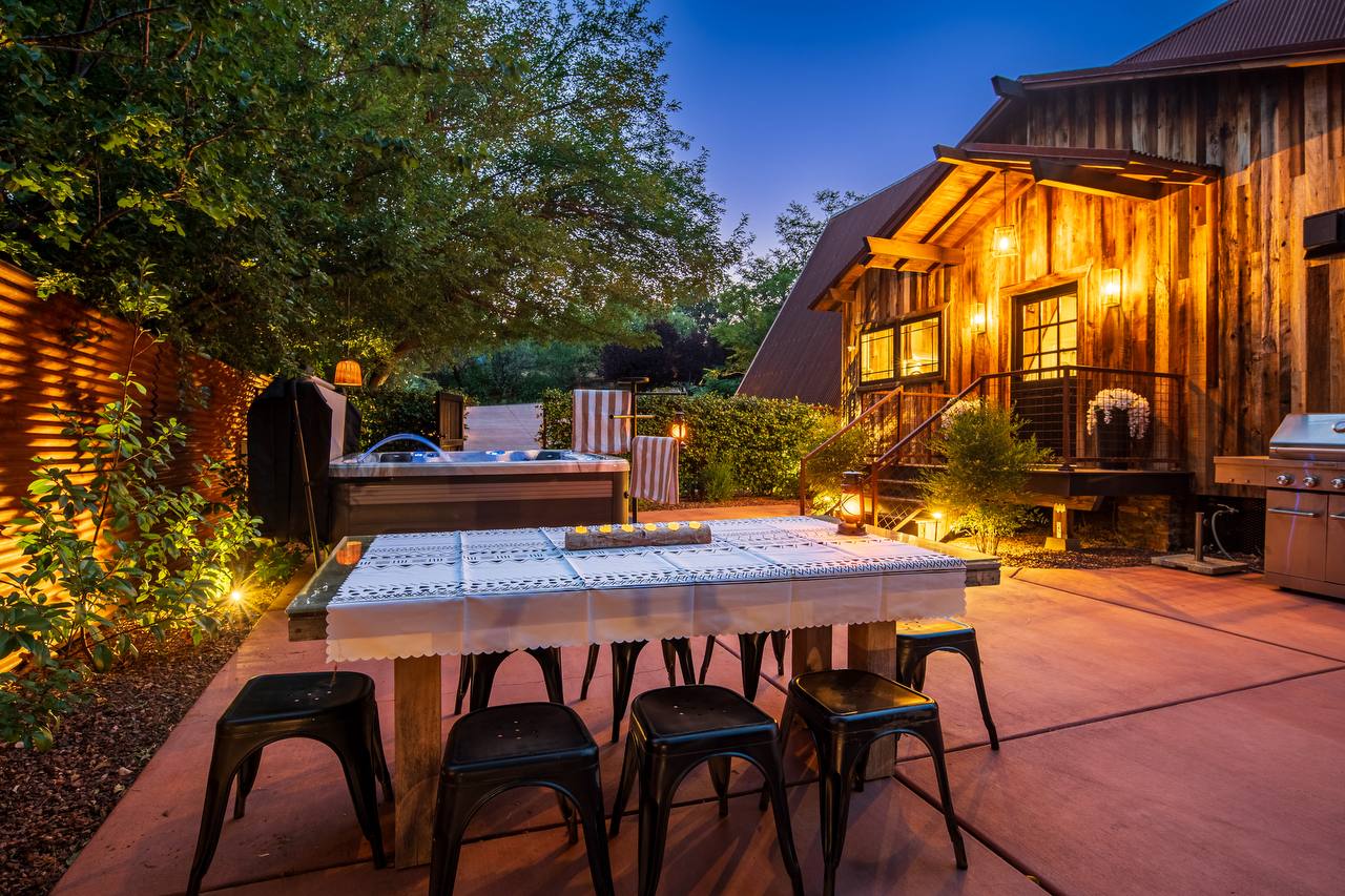Outdoor dining, hot tub, and cabin at twilight — summer