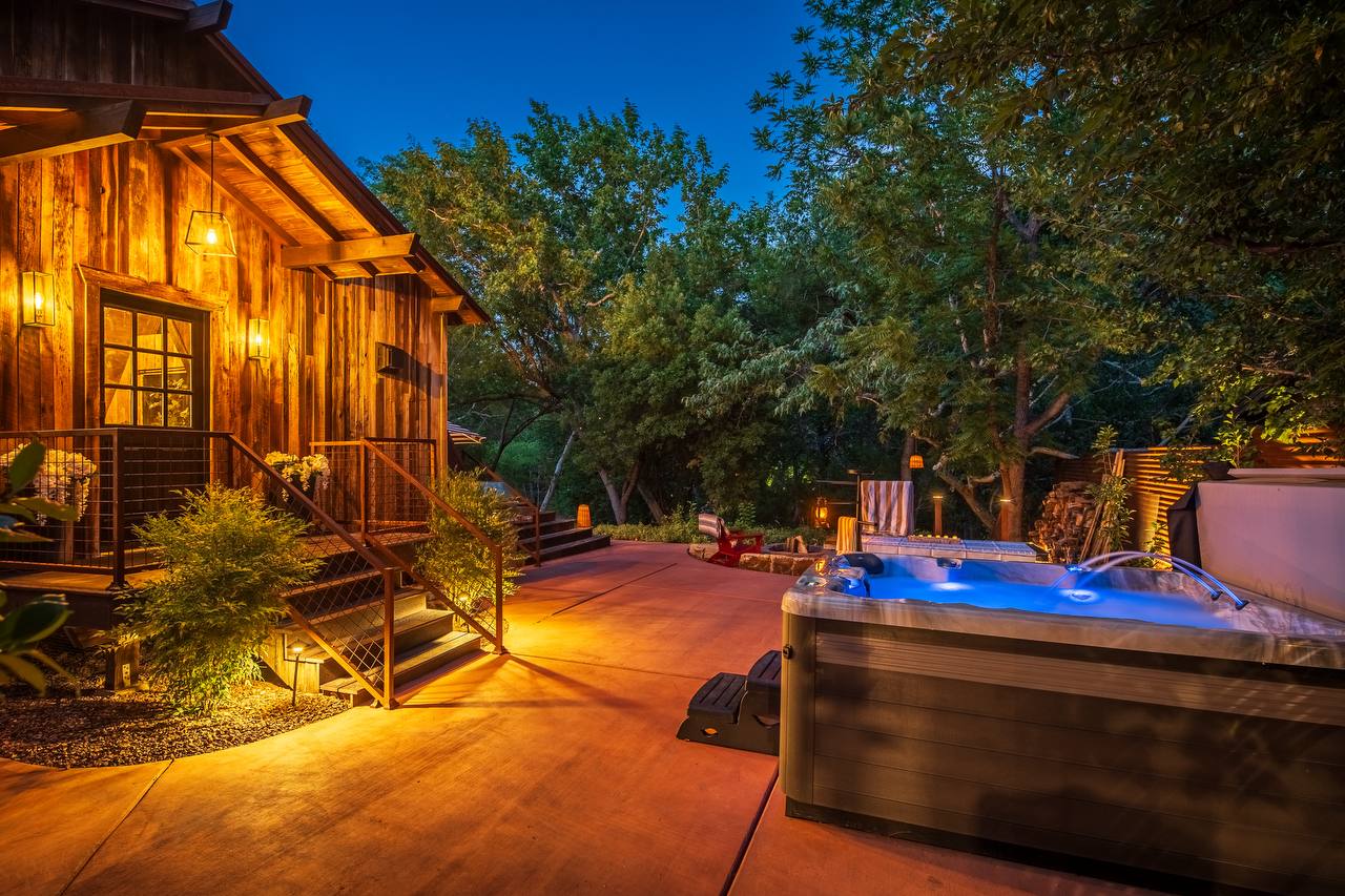 Hot tub with blue light and cabin at twilight — summer